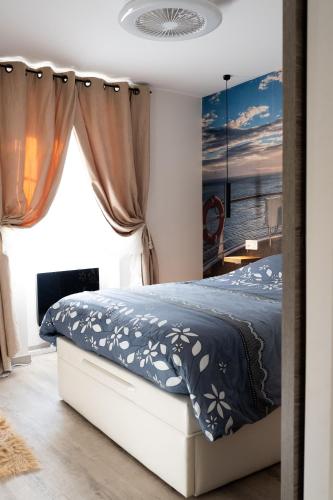 une chambre avec un lit avec une couette bleue dans l'établissement Le Palmier Doré - Calme à Menton jusqu'à 4 personnes, à Menton