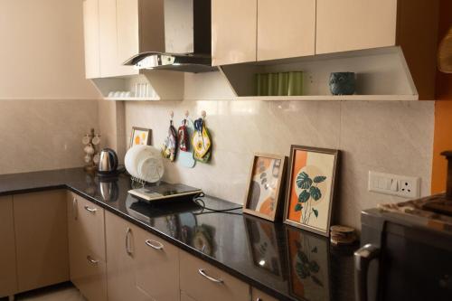 a kitchen with white cabinets and a counter top at Mochastay in Dehradun