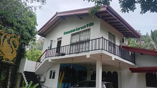 a white building with a balcony on top of it at Cinnamon garden villa in Weligama