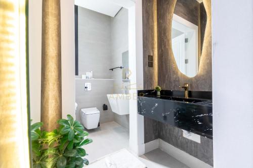 リヤドにあるAmber Hospitality - BLVDの黒い洗面台と鏡のあるバスルーム