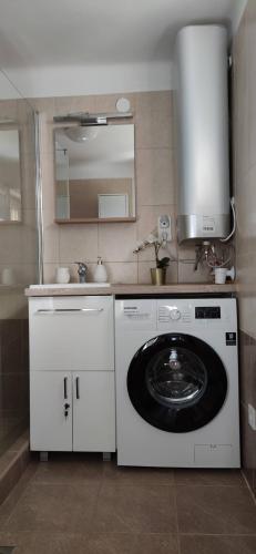 a kitchen with a washing machine and a sink at Bathy Ház in Tiszakécske