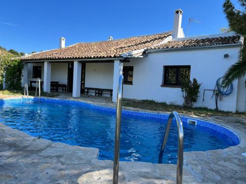 ein Swimmingpool vor einem Haus in der Unterkunft Casa de Campo Cortijo Madrigueras in Algodonales