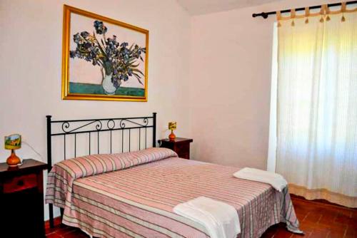 una camera da letto con un letto e un quadro sul muro di Agriturismo Morisfarms - Santa Chiara a Massa Marittima