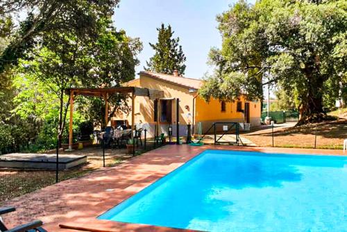 una piscina davanti a una casa di Agriturismo Morisfarms - Santa Chiara a Massa Marittima