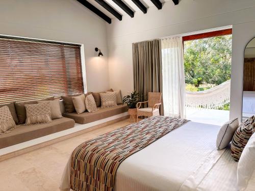 a bedroom with a large bed and a couch at Fina Estampa Country Hotel by HMC - Mayores de 10 años - in Támesis