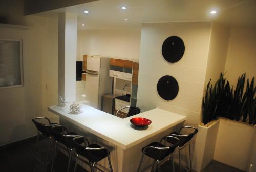 a kitchen with a white counter and some chairs at Rincón del mar Veleros Hotel in San Onofre