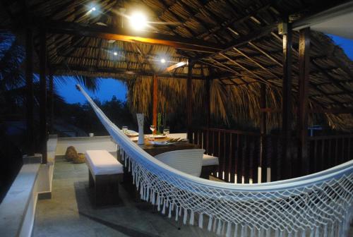 a hammock in a hut with a boat in it at Rincón del mar Veleros Hotel in San Onofre