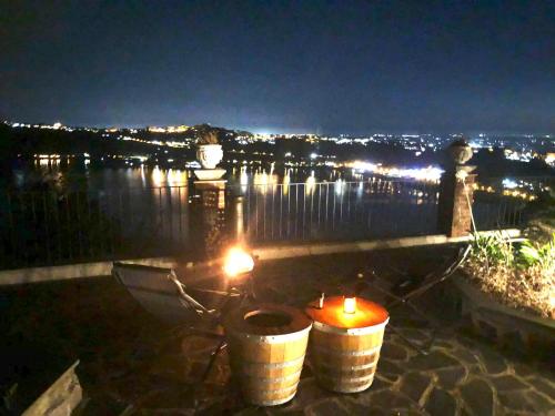 a view of a city at night with candles in barrels at Relais Terrazza sul lago Castelgandolfo in Marino