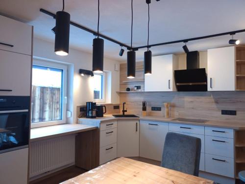 a kitchen with white cabinets and a wooden counter top at Gästehaus Alpenruh in Holzgau