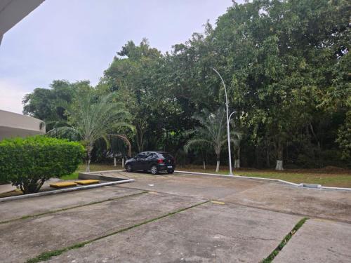 a car parked in a parking lot with trees at Apartamento Manaus Arena da Amazonia in Manaus