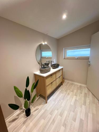 une salle de bain avec un lavabo et un miroir dans l'établissement Bali Room - Espace Zen au cœur de la ville !, à Villeneuve-sur-Lot