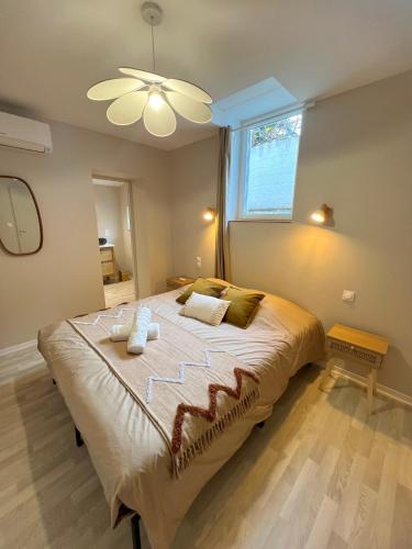 une chambre avec un grand lit avec un ventilateur de plafond dans l'établissement Bali Room - Espace Zen au cœur de la ville !, à Villeneuve-sur-Lot