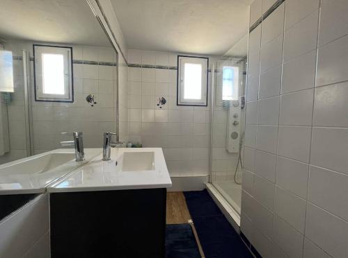 une salle de bain blanche avec un lavabo et une douche dans l'établissement Maison 3 pièces - Gruissan GN500-022, à Gruissan