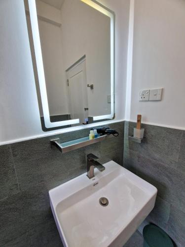 a bathroom with a white sink and a mirror at Villa Sole in Kandy