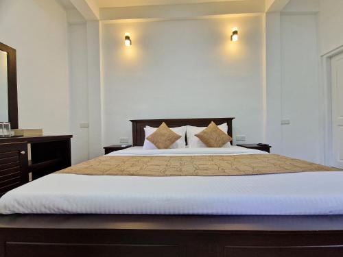 a bedroom with a large bed with two pillows at Villa Sole in Kandy