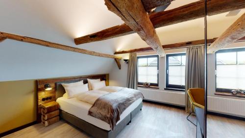 a bedroom with a bed and two windows at Vollmer's Hof in Bad Berleburg