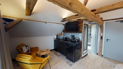 a kitchen and living room with yellow chairs and a table at Vollmer's Hof in Bad Berleburg