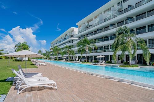 a resort swimming pool with lounge chairs and a hotel at Xeliter Cana Rock Punta Cana in Punta Cana