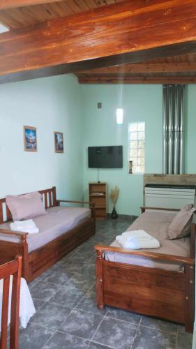 a bedroom with two beds and a flat screen tv at hena apart 1 in Esquel