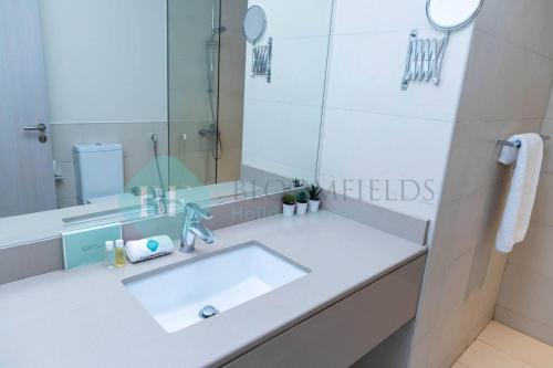 a bathroom with a white sink and a mirror at Bloomfields Elegant 1br In Waters Edge Yas Island in Yas Island