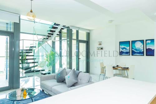 a living room with a couch and a glass table at Bloomfields 2br Duplex Canal View Rahalofts in Abu Dhabi