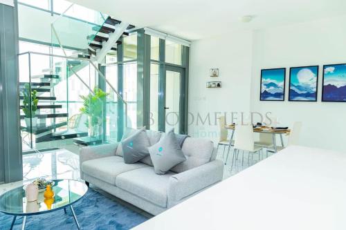 a living room with a couch and a glass table at Bloomfields 2br Duplex Canal View Rahalofts in Abu Dhabi