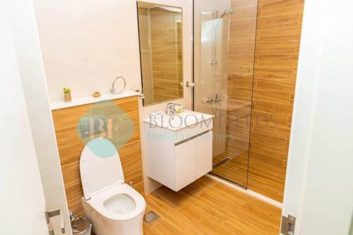 a bathroom with a toilet and a shower at Bloomfields 2br Duplex Canal View Rahalofts in Abu Dhabi