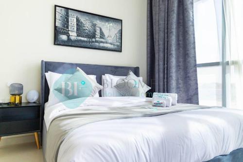 a bedroom with a bed with white sheets and a window at Bloomfields Magnificent Stu In View Raha Beach in Abu Dhabi