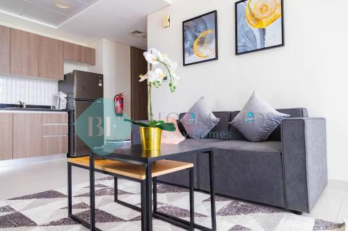 a living room with a couch and a table at Bloomfields Magnificent Stu In View Raha Beach in Abu Dhabi
