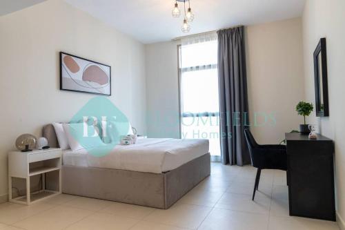 a bedroom with a bed and a desk and a window at Bloomfields Stylish 1br In Reflections Al Reem in Mushayrib