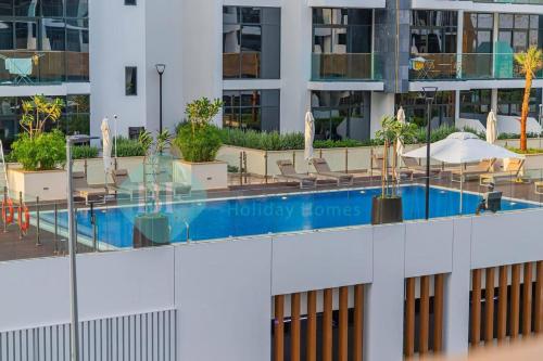 a swimming pool on the side of a building at Bloomfields Cozy Stu Azizi Riviera Meydan in Dubai