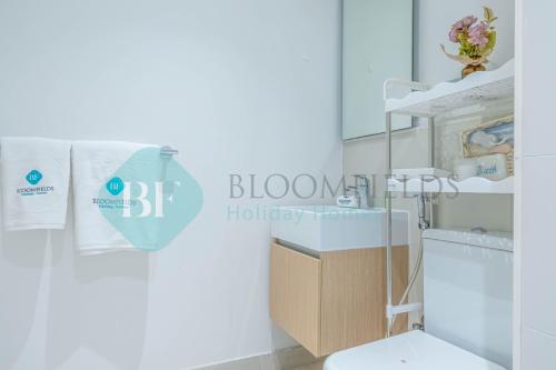 a bathroom with a white toilet and a sink at Bloomfields Metropolitan 3br In Bridges in Abu Dhabi