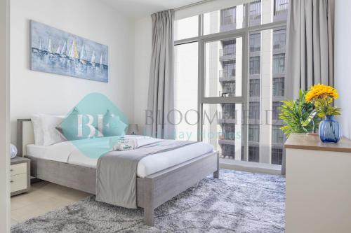 a bedroom with a bed and a large window at Bloomfields Metropolitan 3br In Bridges in Abu Dhabi