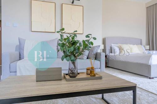 a living room with a table and a couch at Bloomfields Cozy Stu In The View Raha Beach in Abu Dhabi