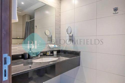 a bathroom with a sink and a mirror at Bloomfields Cozy Stu In The View Raha Beach in Abu Dhabi