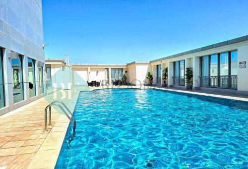 a large swimming pool in front of a building at Bloomfields Hidden Gem 1br In Elyacout Tower in Abu Dhabi