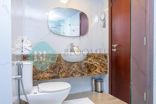 a bathroom with a toilet and a mirror at Bloomfields Hidden Gem 1br In Elyacout Tower in Abu Dhabi