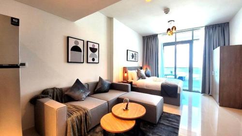 ein Wohnzimmer mit einer Couch und einem Bett in der Unterkunft Bloomfields Stu With Canal View Julphar Al Reem in Abu Dhabi