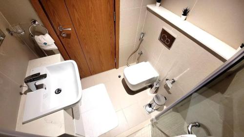 ein Badezimmer mit einem weißen Waschbecken und einer Toilette in der Unterkunft Bloomfields Stu With Canal View Julphar Al Reem in Abu Dhabi