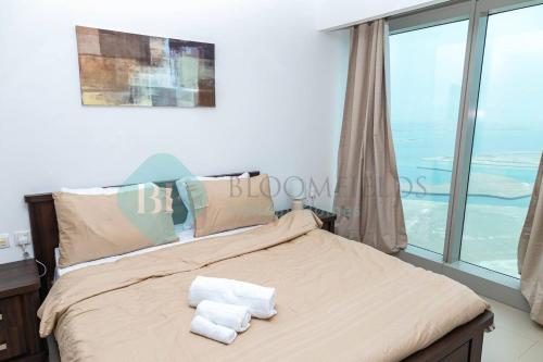 MushayribにあるBloomfields 1br Amazing Sky View At Gate Towerのベッドとタオル2枚のある寝室