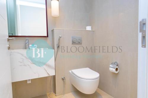 a bathroom with a white toilet and a sink at Bloomfields Iconic 2br & Maid Address Beach Resort in Fujairah