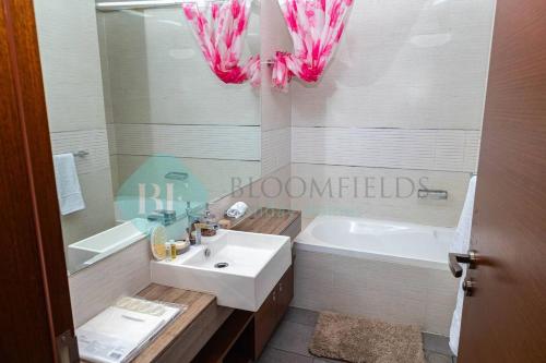 MushayribにあるBloomfields 1br Amazing Sky View At Gate Towerの白いバスルーム(シンク、バスタブ、シンク付)