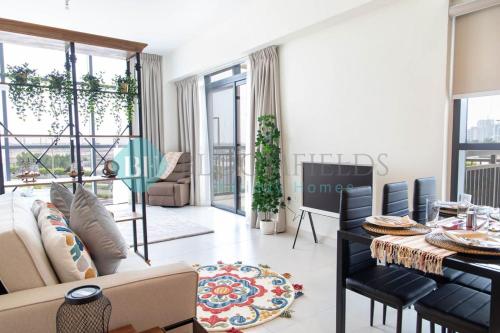 a living room with a table and chairs and a dining room at Bloomfields Artistic Stu In The View Raha Beach in Abu Dhabi