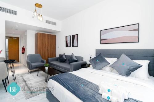 Un dormitorio con una cama y una sala de estar. en Bloomfields Premium Stu In Oasis Masdar City, en Abu Dhabi Intl