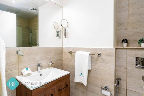 un baño con lavabo y espejo en Bloomfields Premium Stu In Oasis Masdar City, en Abu Dhabi Intl