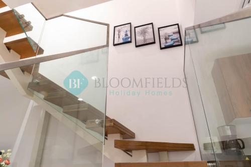 a staircase in a house with a sign that reads bloomfield holiday homes at Bloomfields Stylish 2br In Oasis Masdar City in Al Qurayyah