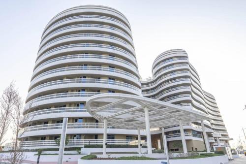 a large white building with a metal structure in front of it at Bloomfeilds Modern 1br Soul Beach Access in Abu Dhabi