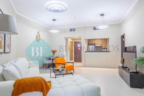 a living room with a white couch and a table at Bloomfeilds Modern 1br Soul Beach Access in Abu Dhabi