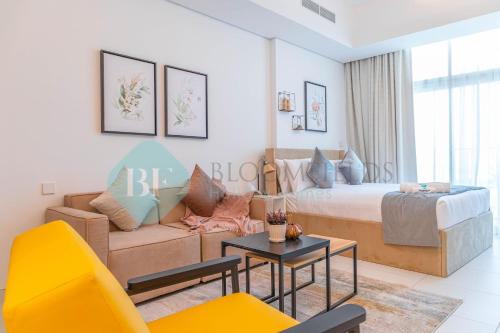 a living room with a bed and a couch at Bloomfields Spacious Stu In Thalassa Beach Front in Abu Dhabi