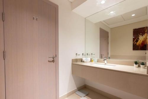 ein Badezimmer mit Waschbecken und Spiegel in der Unterkunft Bloomfields Iconic 1br Waters Edge Yas Island in Abu Dhabi